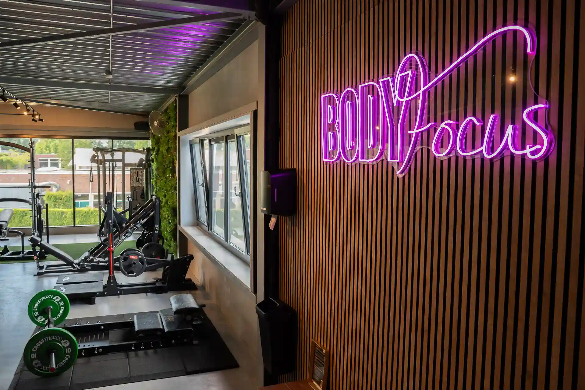 Body Focus neon logo naast de krachttrainingsruimte bij Body Focus
