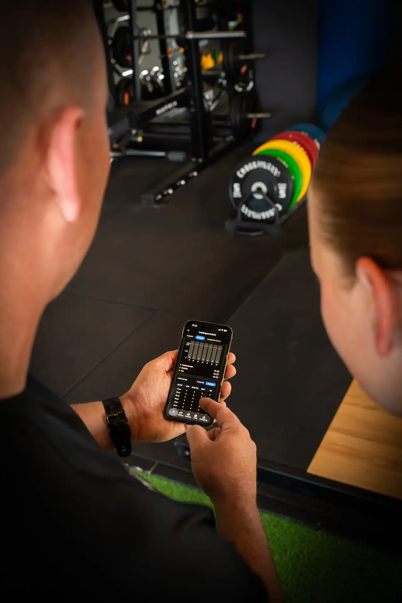 Trainer en lid bekijken samen het voedings- en voortgangsoverzicht in de Body Focus app